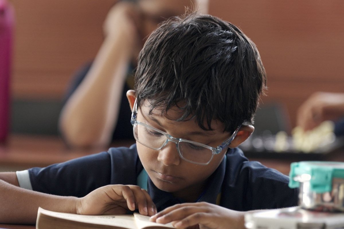 A boy absorbed in a book at his desk.