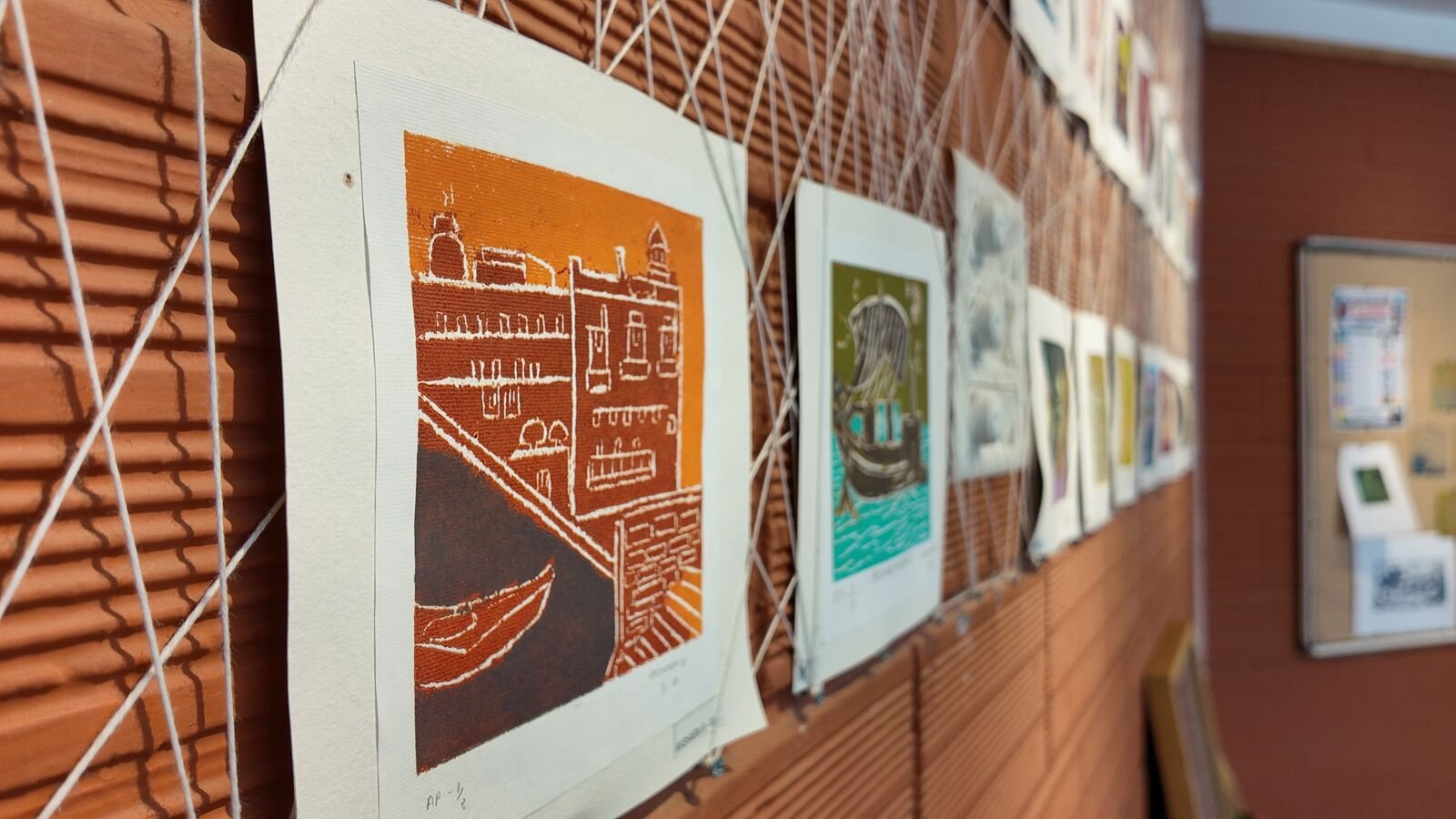 A row of student prints hung on a wall.