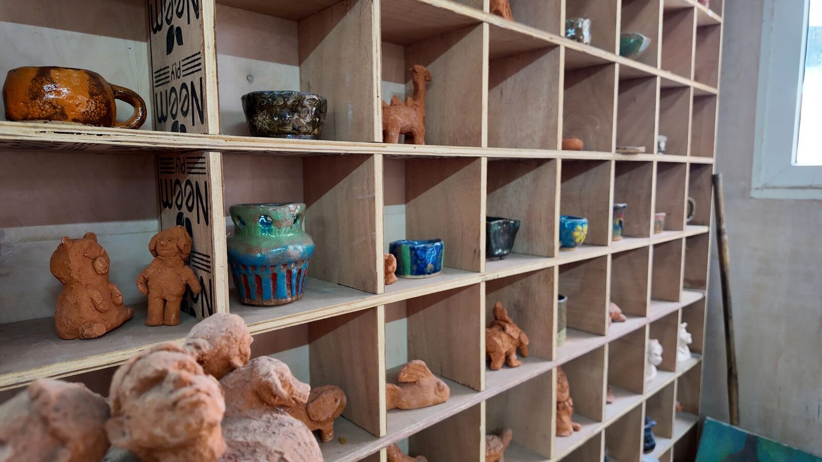 Glazed pots and mugs made by students.