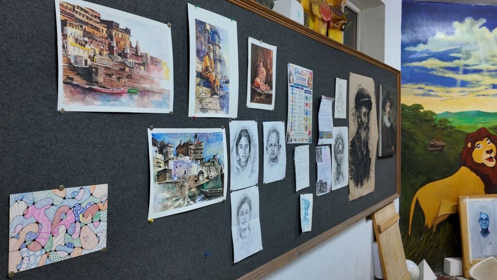 Student drawings and paintings displayed in the art studio.