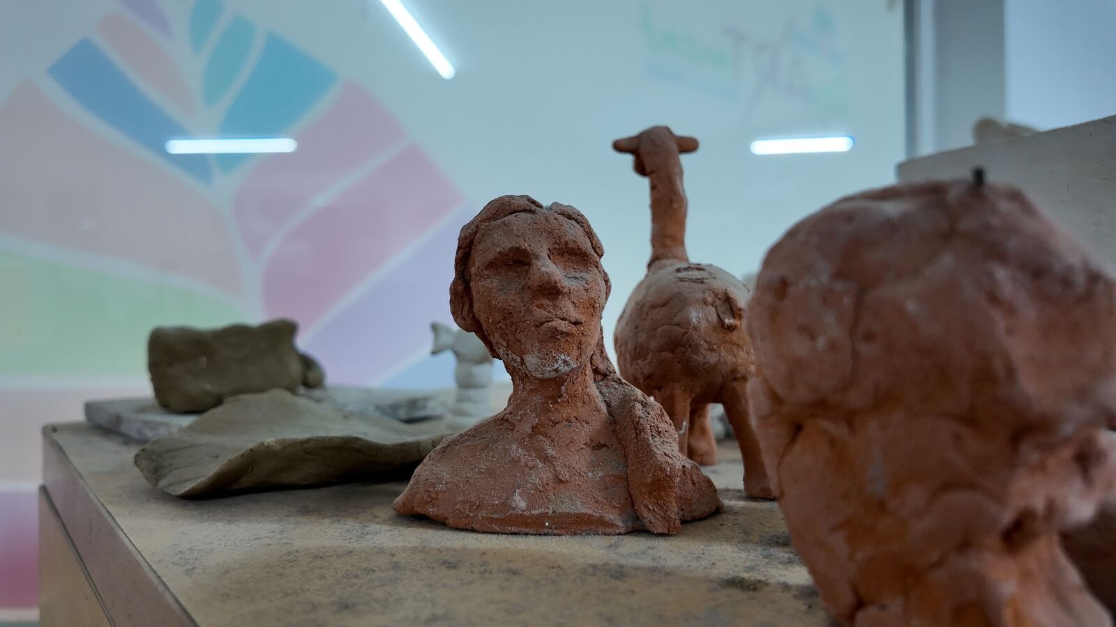 A fired terracotta bust and animal sculpted by students.