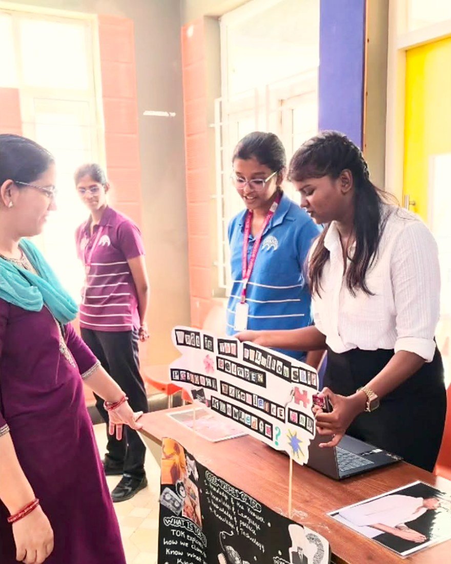 A Diploma student explaining her TOK Exhibition project to a teacher.