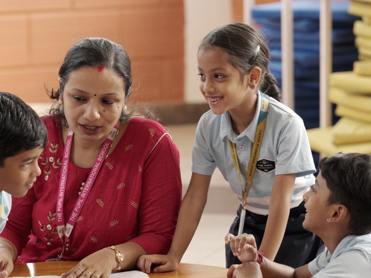 A teacher supporting pupils during a shared learning activity.