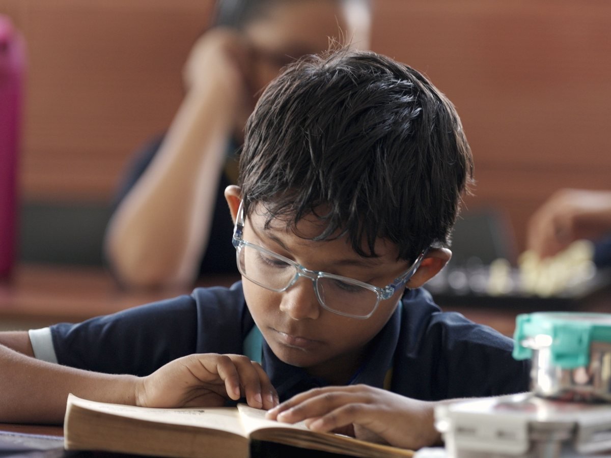 A pupil concentrating on independent reading or writing.