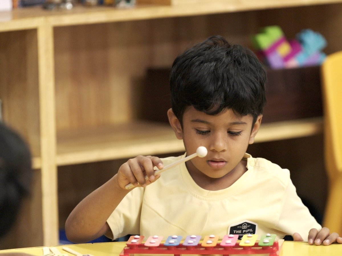 A young boy playing a toy xylophone.