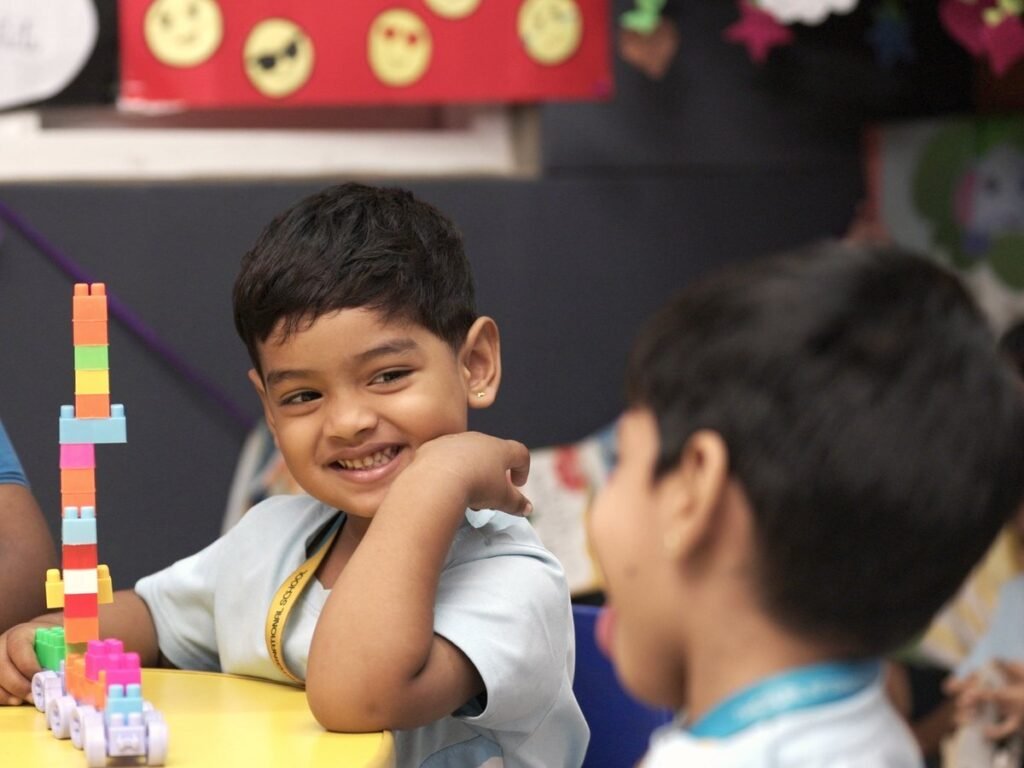 A child beside a construction made with blocks.