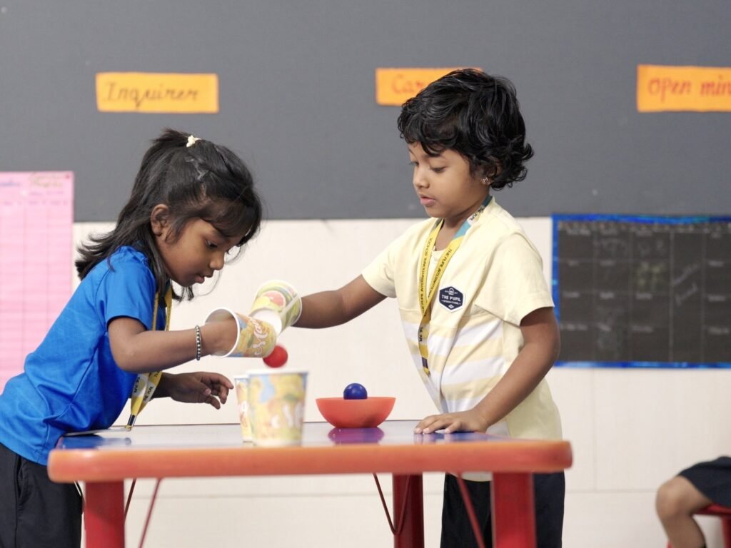 Children exploring water at an activity table.