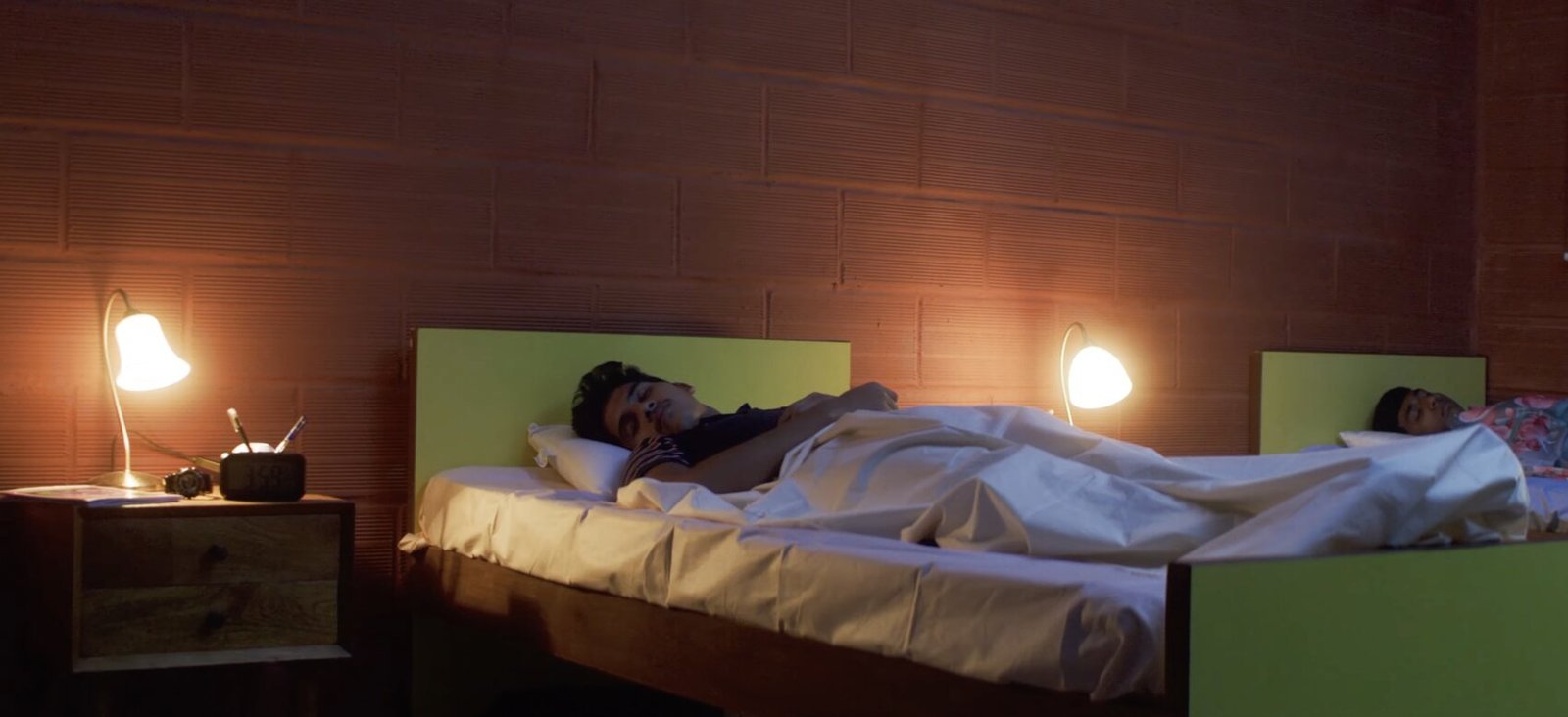 Boarders asleep in their beds at the Abode, with bedside lamps on.
