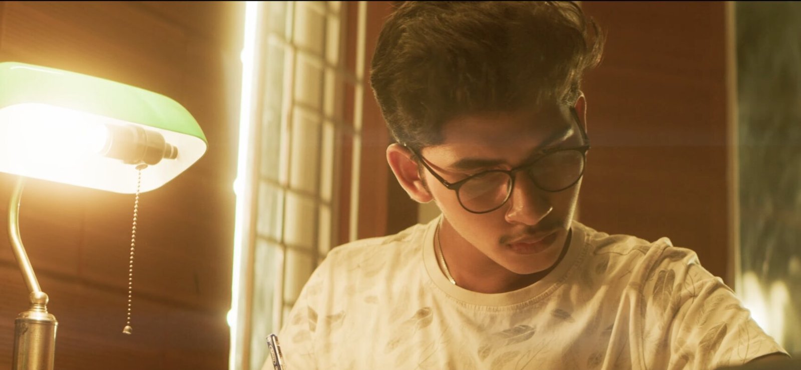 A boarder studying by lamplight in the evening.