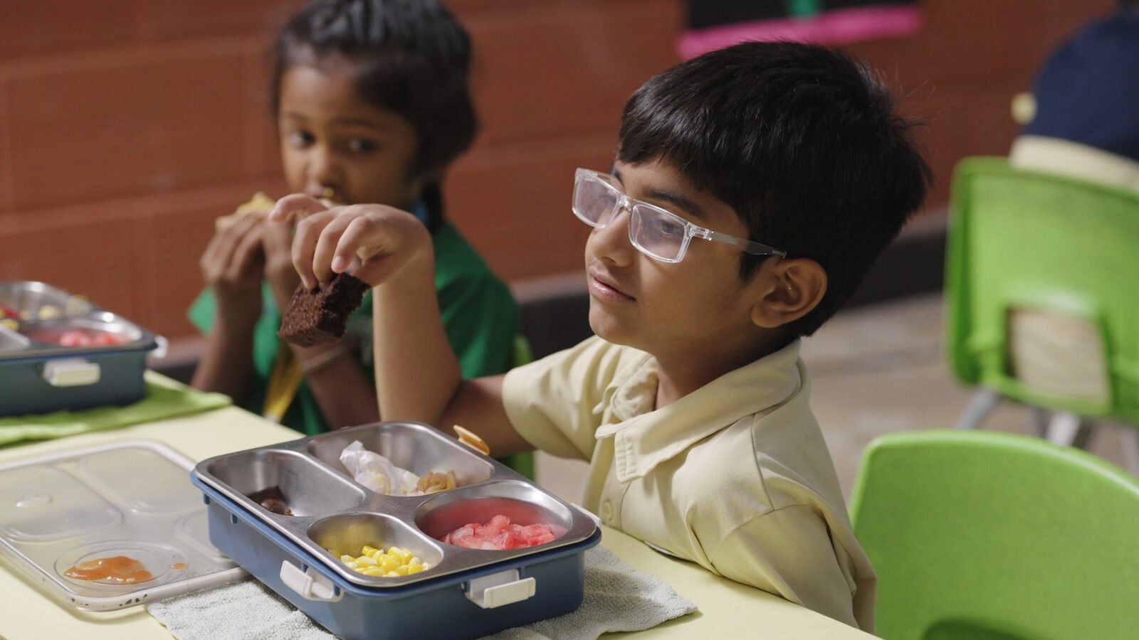 A young student eating his bento box lunch in class.