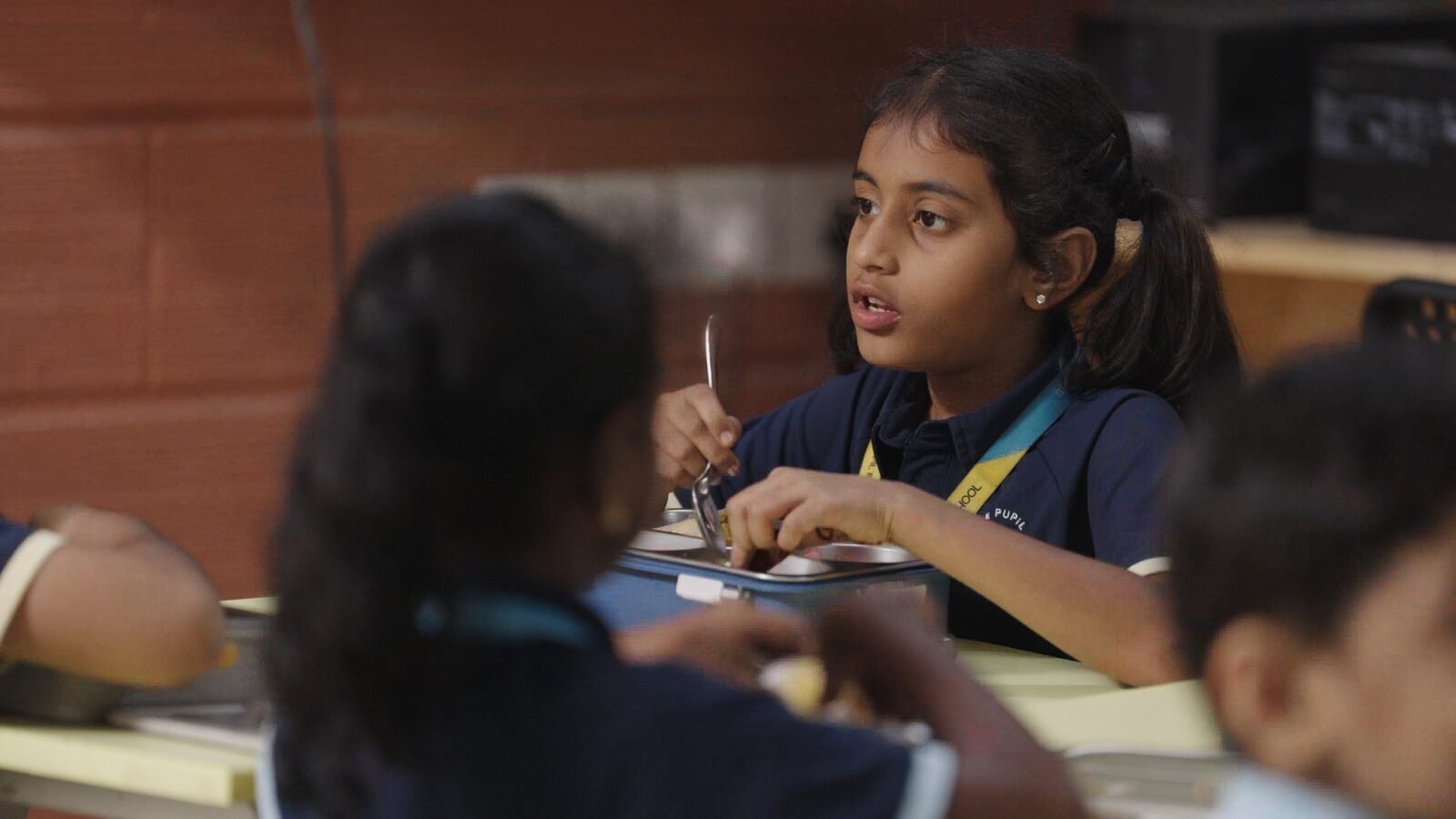 An older student chatting with friends over lunch.