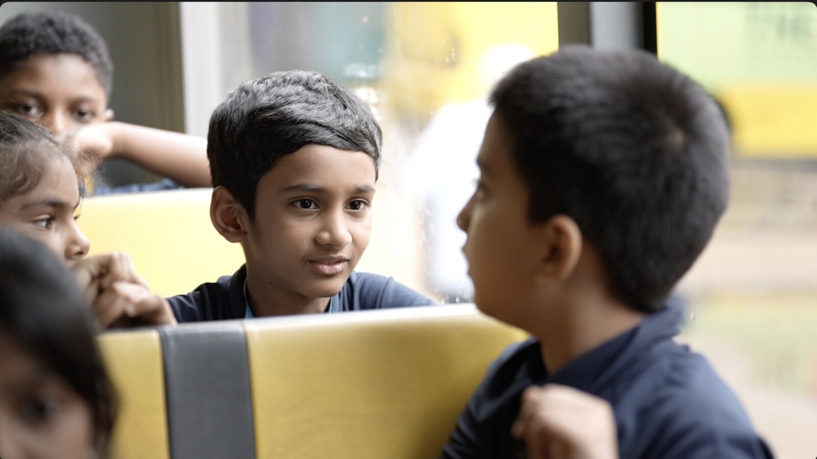 A boy chatting with friends on the school bus.