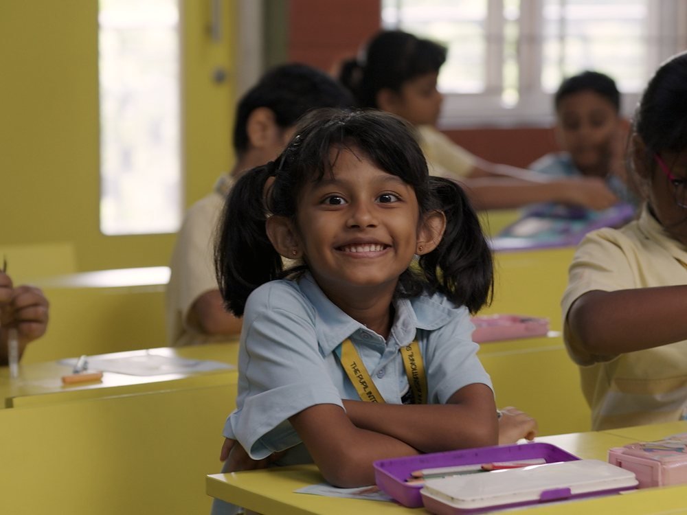 A child raising a hand during a classroom activity.