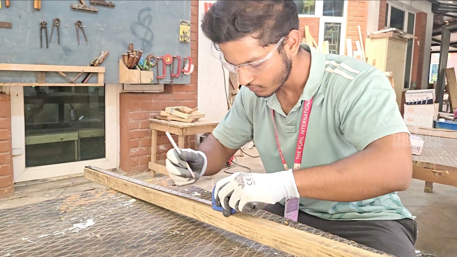 A student using tools to measure and mark wood.