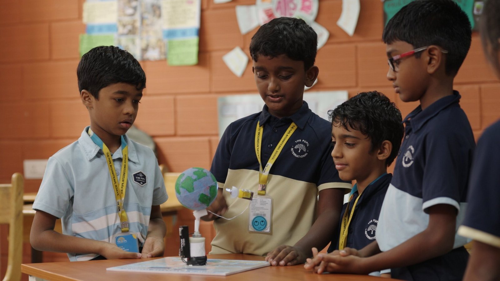 Children testing a model globe together.