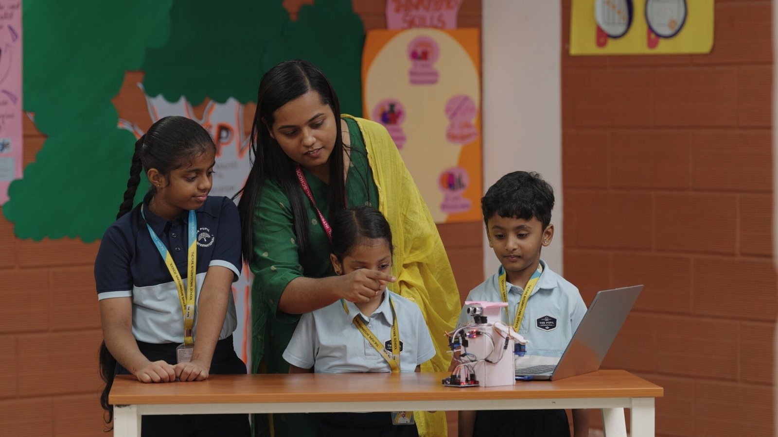 Students exploring robotics with guidance from a teacher.