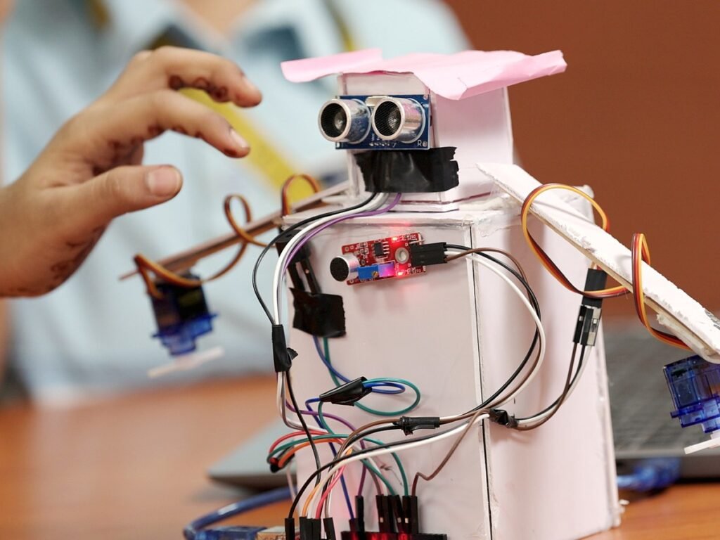 A student adjusting a robot.