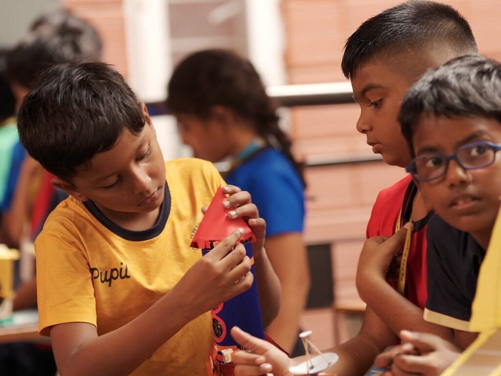 Students examining a paper model.
