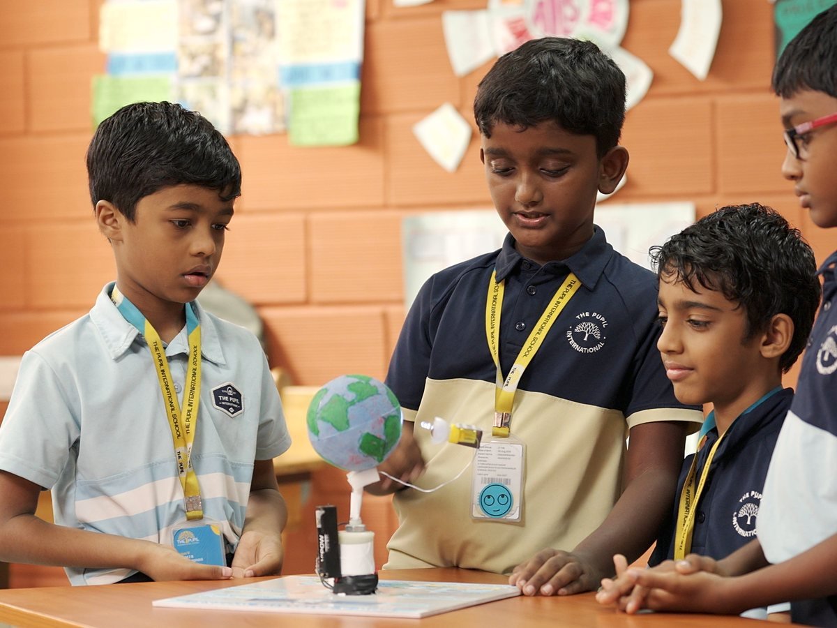 Boys explaining the globe model they built.
