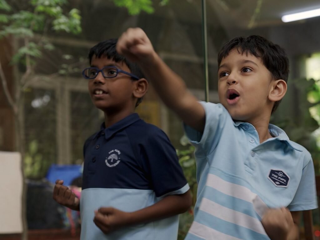 Two students cheering outdoors.