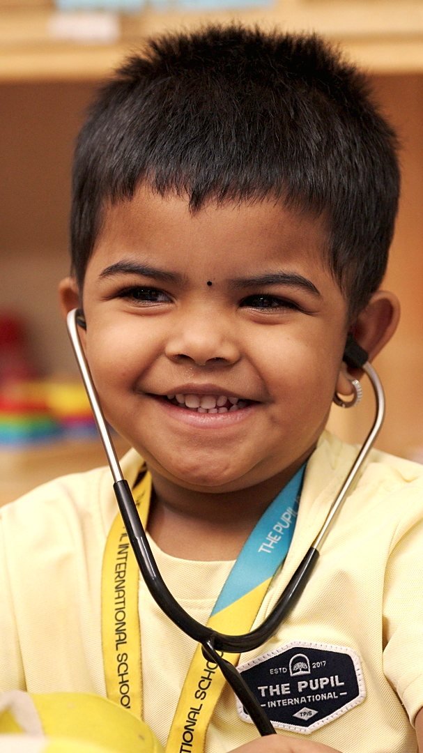 A smiling upside-down face and yellow sweater outdoors.