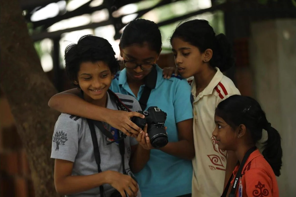 Photography Club members looking at a shot on a camera together.