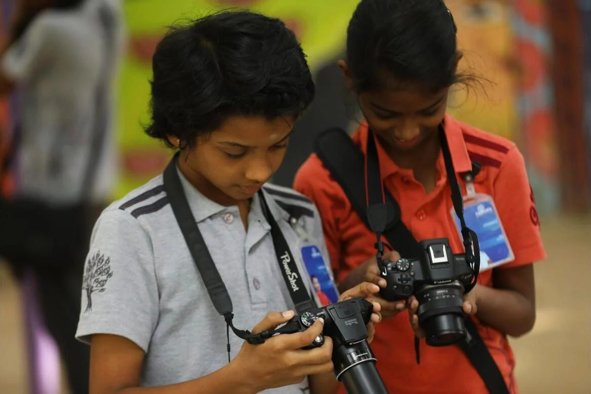Two Photography Club students checking their shots on their cameras.