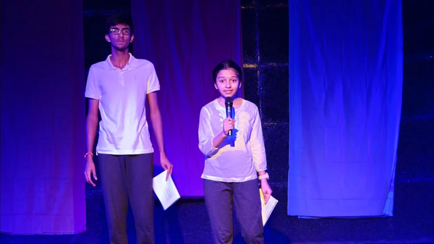 Two Theatre Club students presenting on stage.