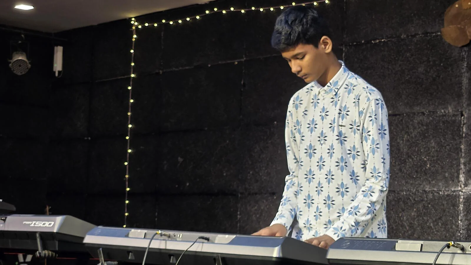 A student playing the keyboard on stage.