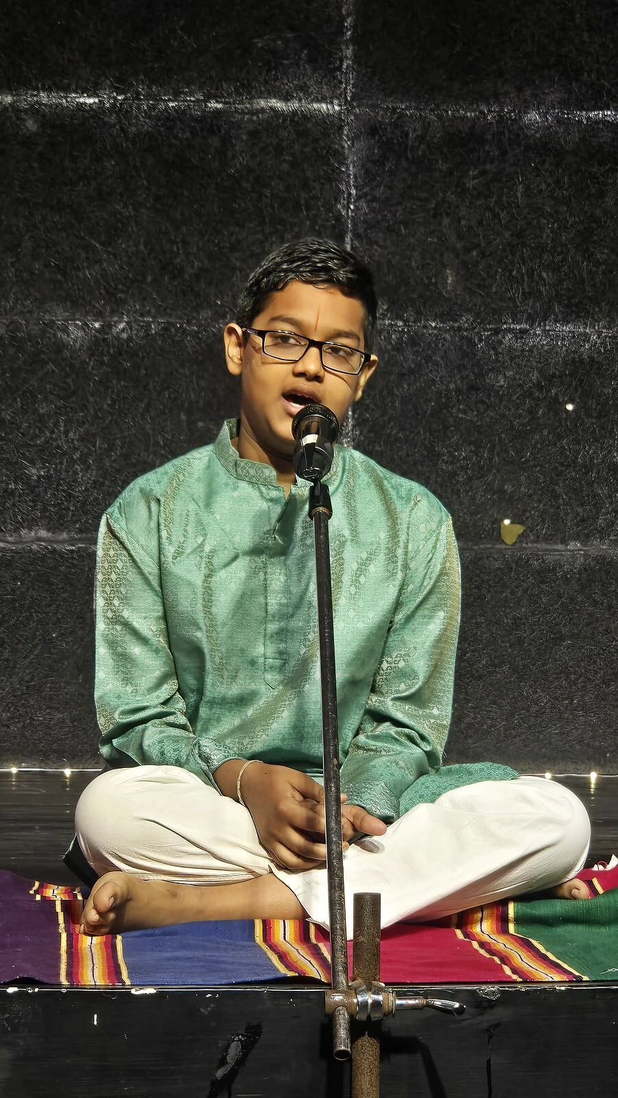 A boy singing at the microphone.