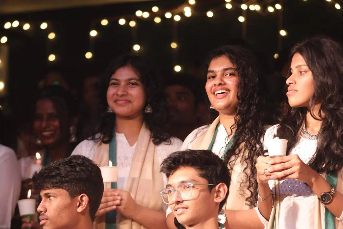 Senior students holding candles during carol singing.