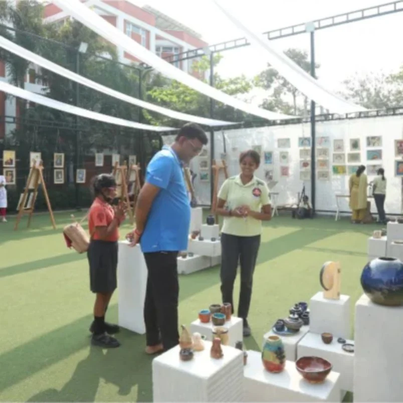 Families looking at student pottery on display at the exhibition.