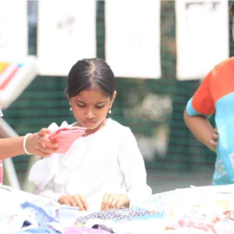 A young student looking closely at work on display.
